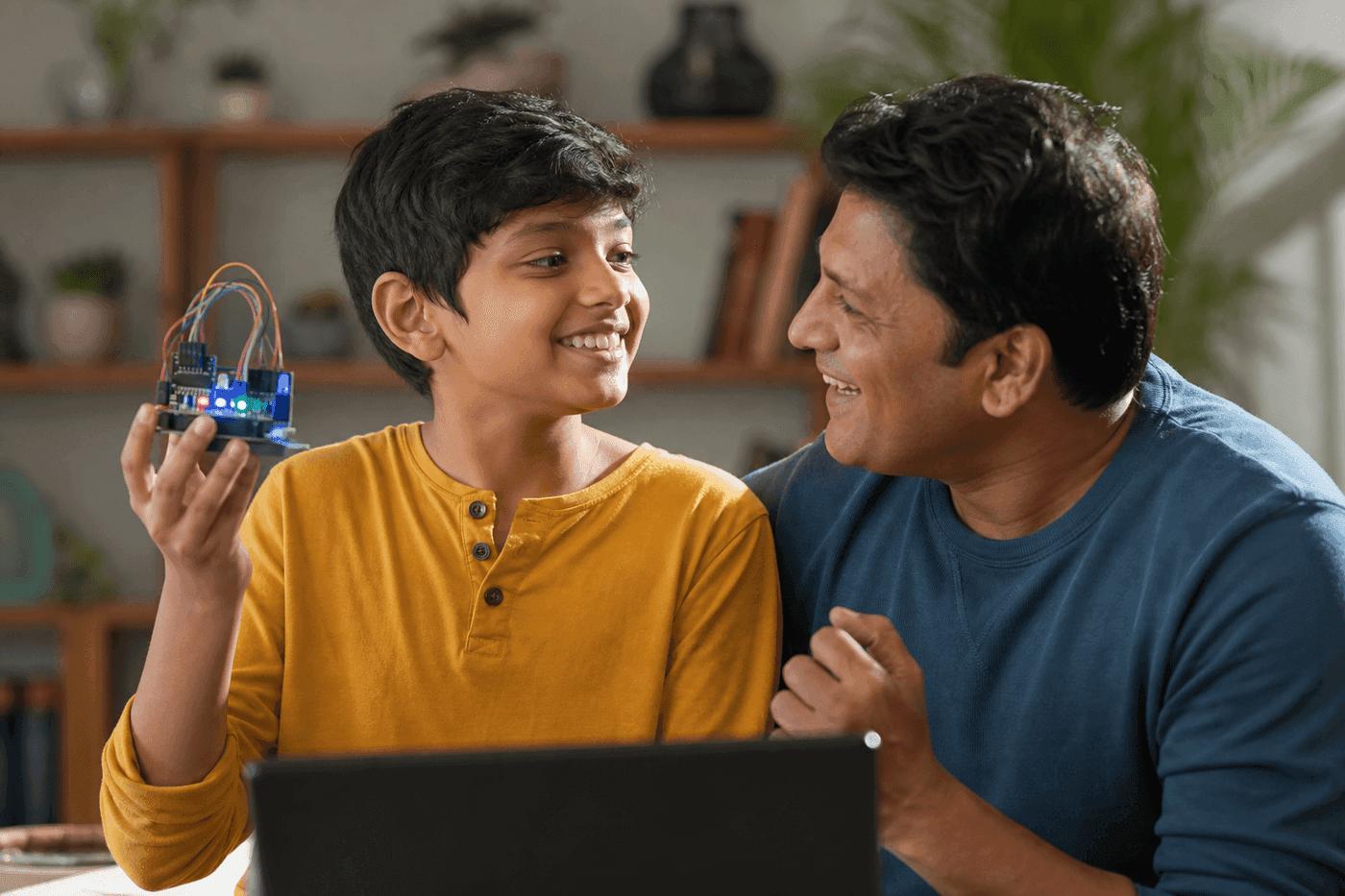 Child proudly showing a finished electronics project to a parent
